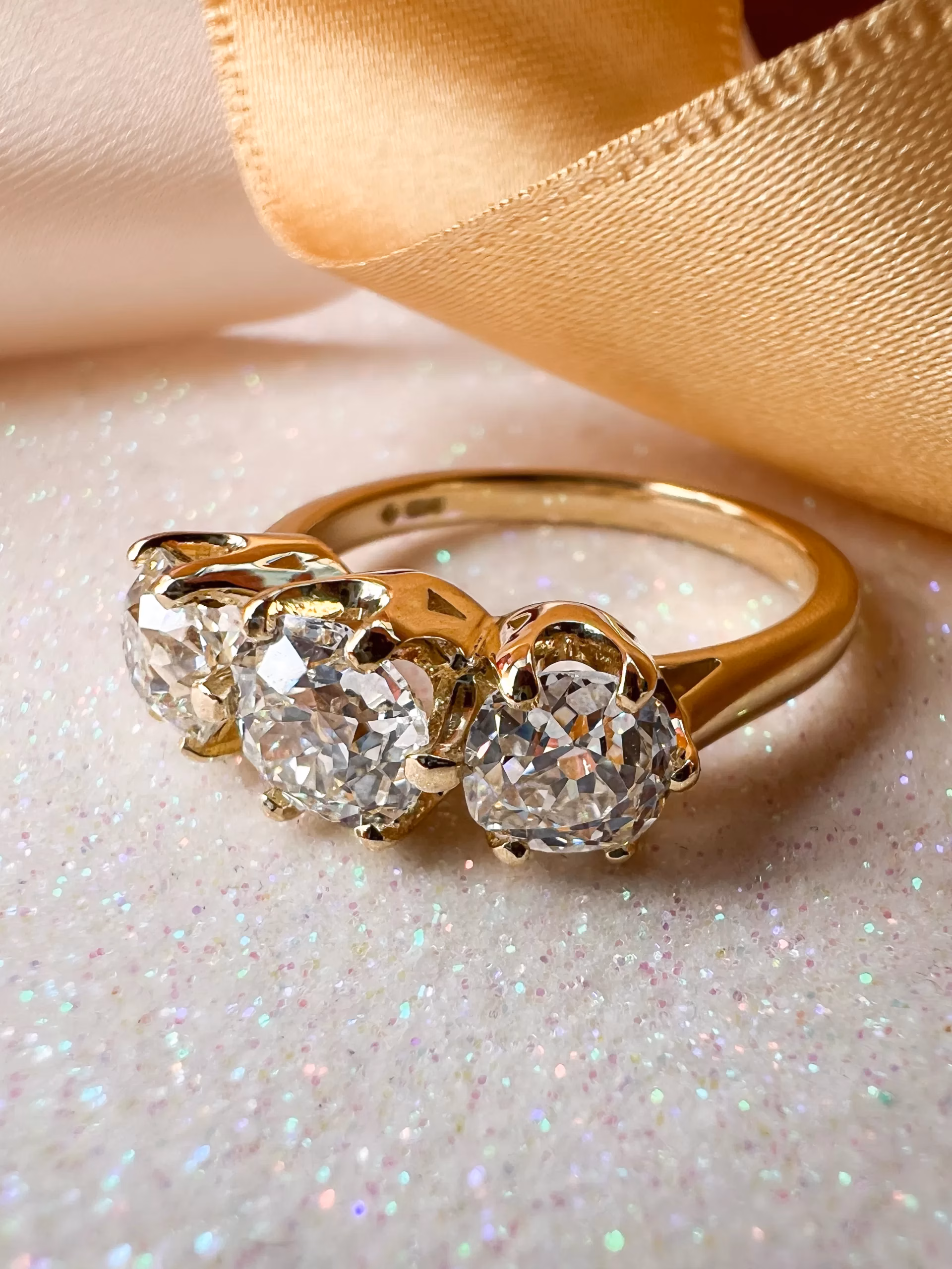 Custom Old Cut Diamond Three-Stone Ring on sparkly paper