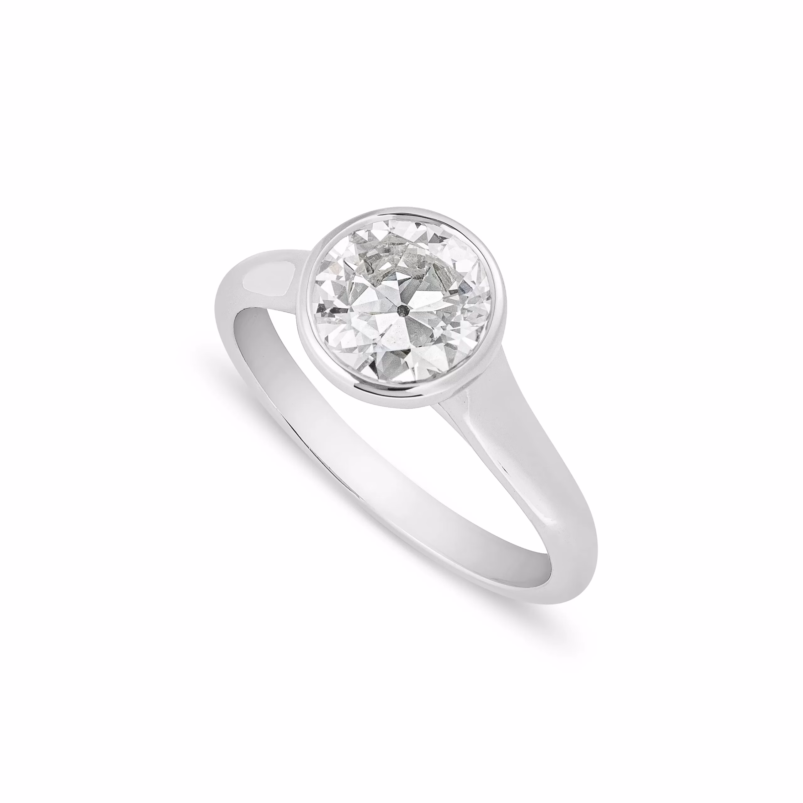 A round old cut diamond solitaire engagement ring in a smooth bezel setting, photographed against a white background to show its clean, modern profile.